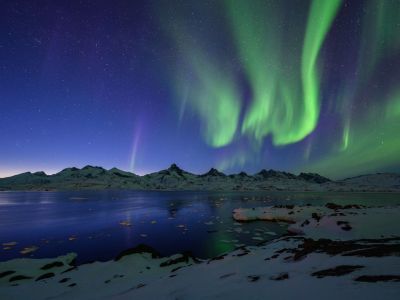 Polarlichter über Tasiilaq in Ostgrönland. Grönland liegt unter dem Nordlichtgürtel, die Bedingungen