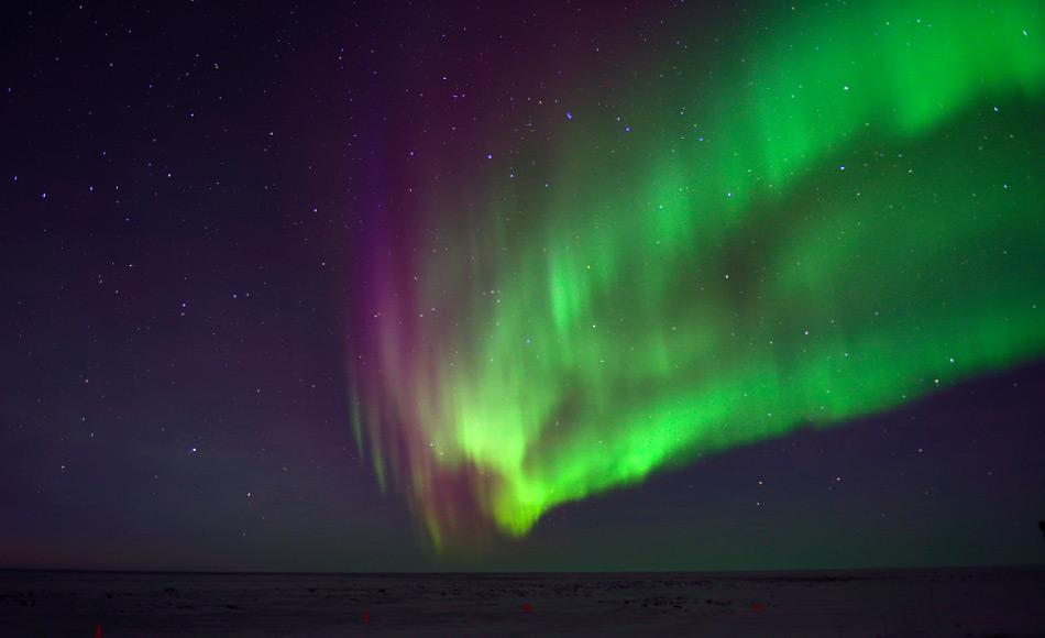 Je nachdem, ob Elektronen mit Sauerstoff oder Stickstoff kollidieren, ist das resultierende Licht entweder grün oder rot, so dass die Aurora einen wirbelnden Vorhang aus verschiedenen Lichtfarben bildet.  Bild: Michael Wenger