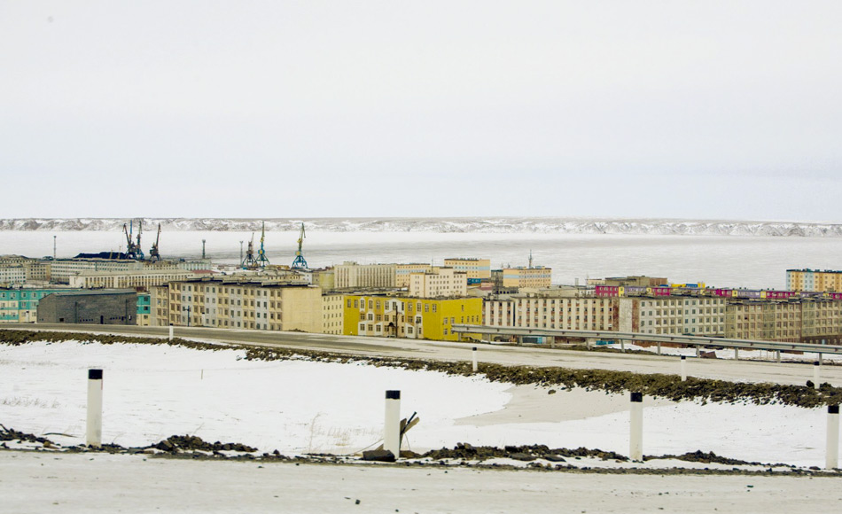 Blick auf Pevek aus dem Süden. Pevek ist eine arktische Hafenstadt auf einer Halbinsel an der Ostseite der Tschaunbucht (ein Teil der Ostsibirischen See). Sie ist die nördlichste Stadt in Russland und Asien und wurde nach dem Ersten Weltkrieg gegründet, um einen Hafen für den Export von Mineralien als Teil des expandierenden Nördlichen Seewegs zu schaffen. Bild: Brian Tibbets